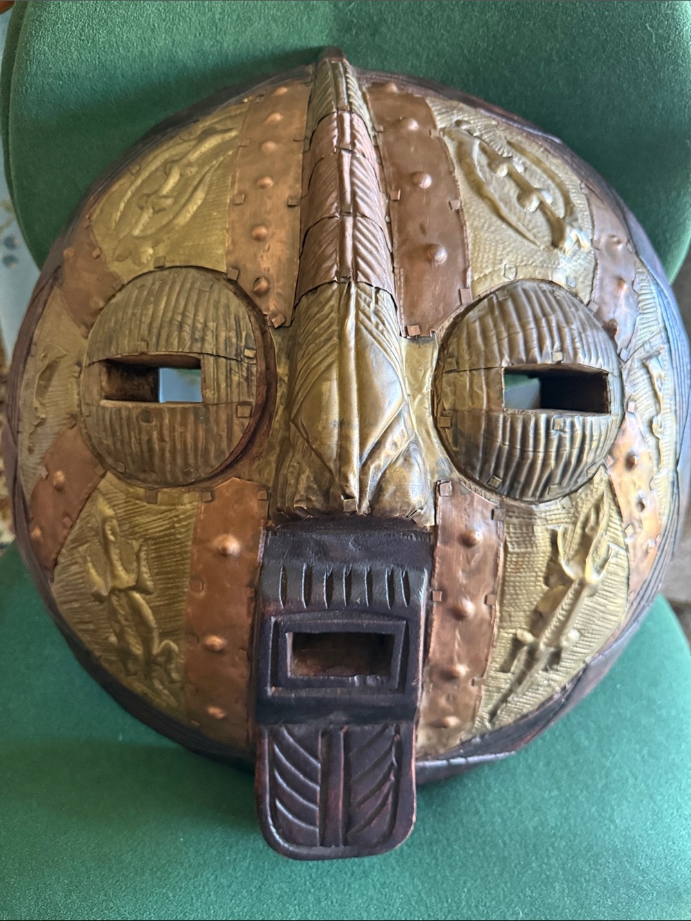 handcrafted Ghanaian wooden wall mask,  intricate aluminum and brass accents.